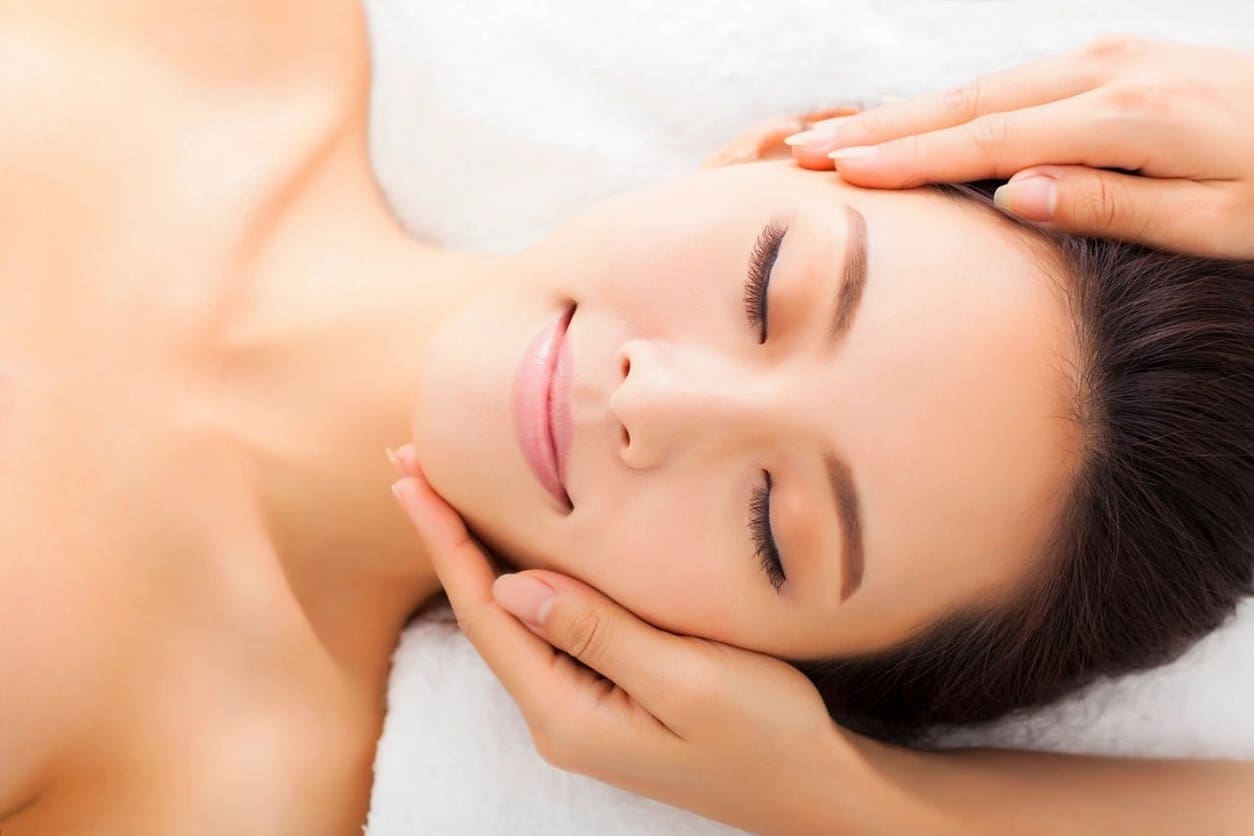 A woman is getting her face washed with lotion.