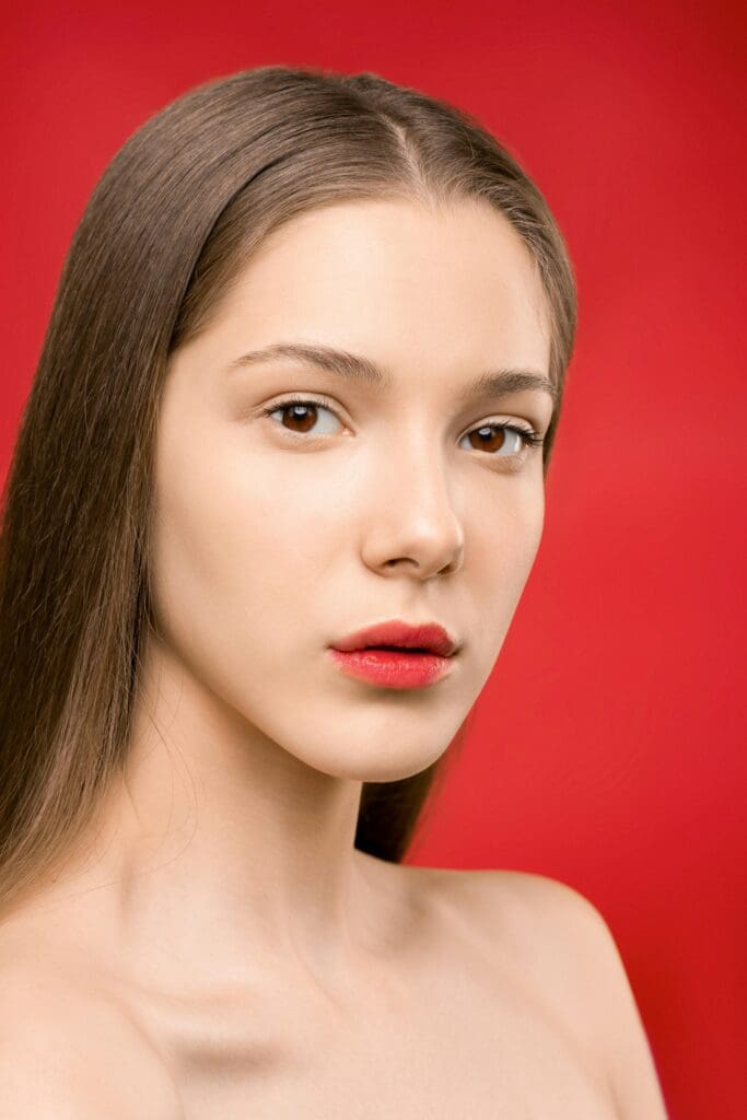 A woman with long hair and red lipstick.