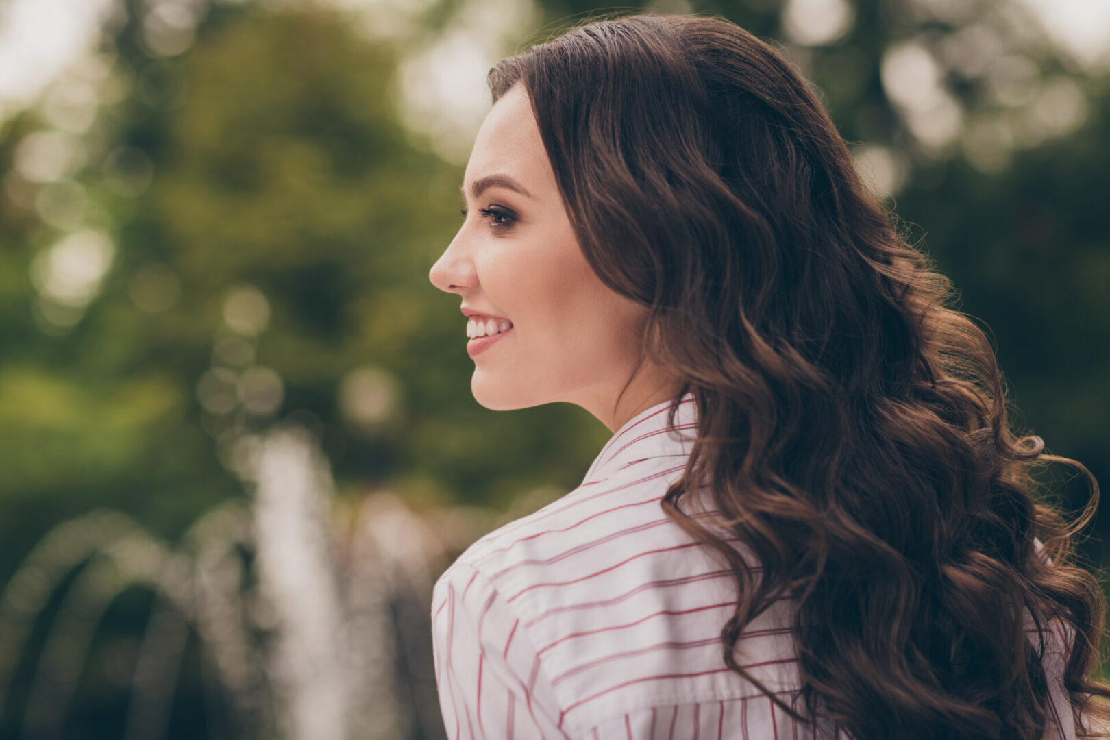 A woman with long hair is smiling.