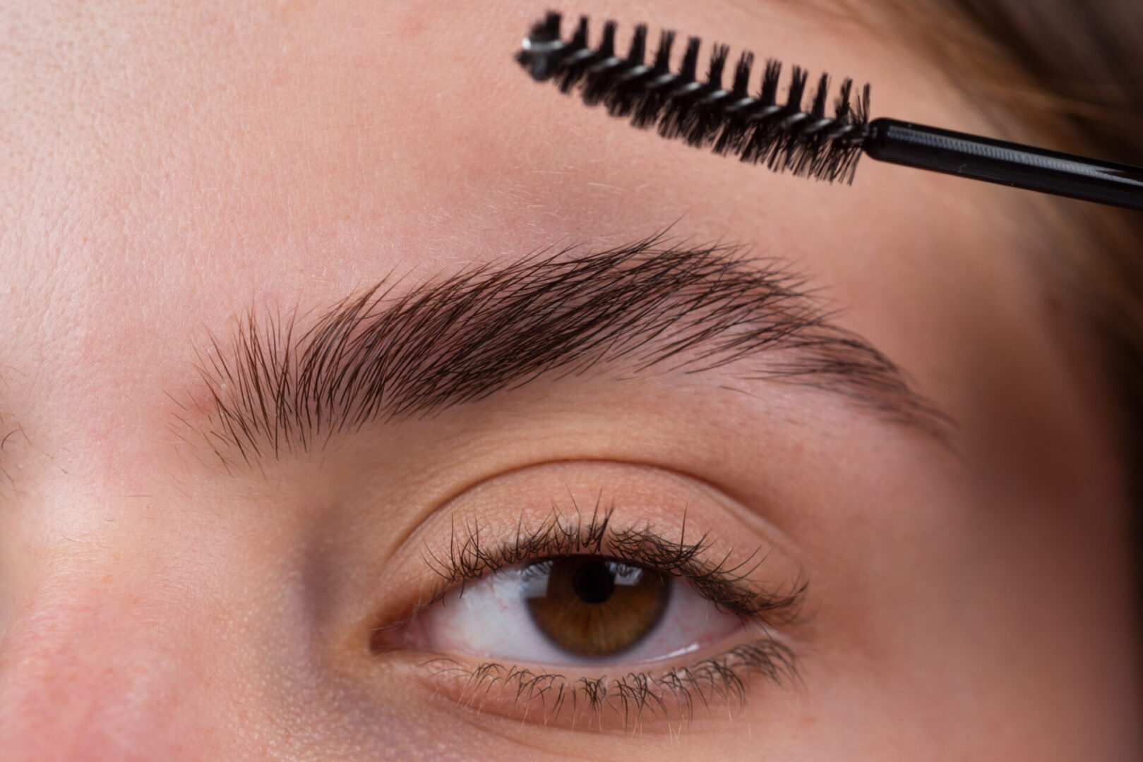 A close up of a person with a brush on their brow